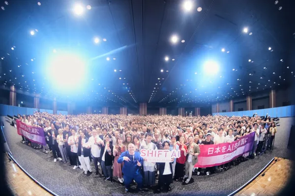 AI関連イベントで多数の参加者が会場に集まり、ステージ前で集合写真を撮影している様子